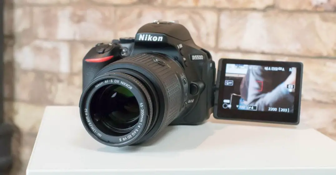 black nikon camera on a white table with rocky background