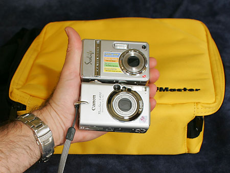holding a digital camera infront of a yellow bag