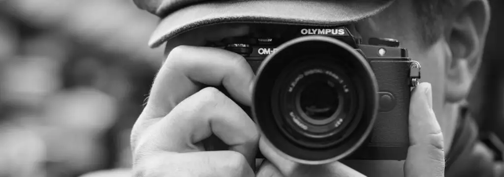 A person taking a picture using Olympus camera