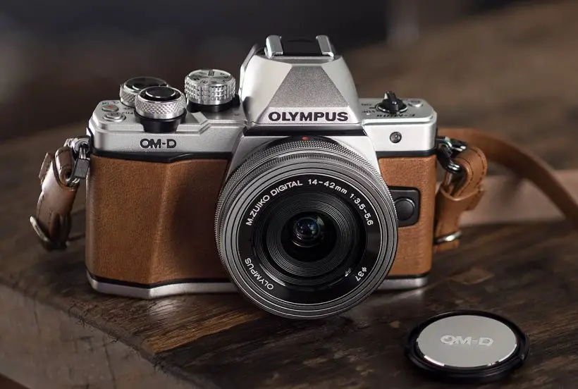 Olympus OM-D E-M10 Mark II camera is placed on the wooden table
