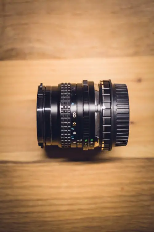black camera lens on a wooden surface