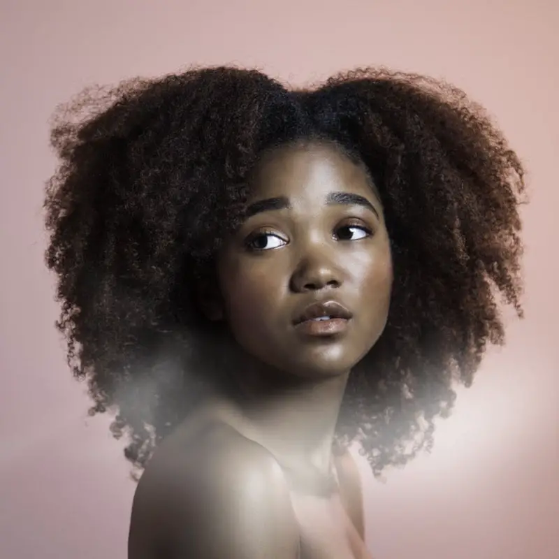 curly hair black girl with brown pink background