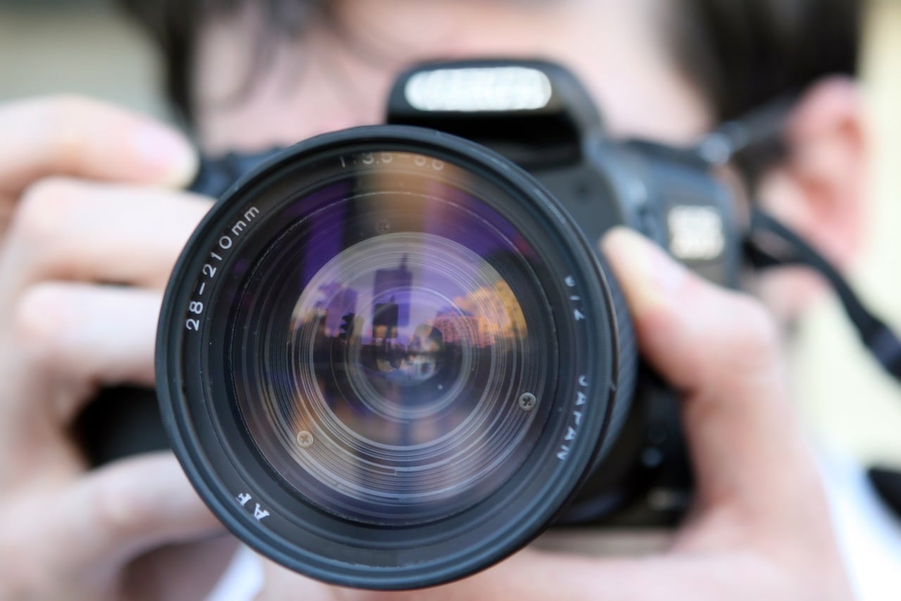 close up picture of a man holding a black camera