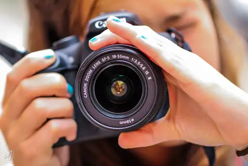 Woman holding a Canon 750D with 18-55mm IS STM Lens camera