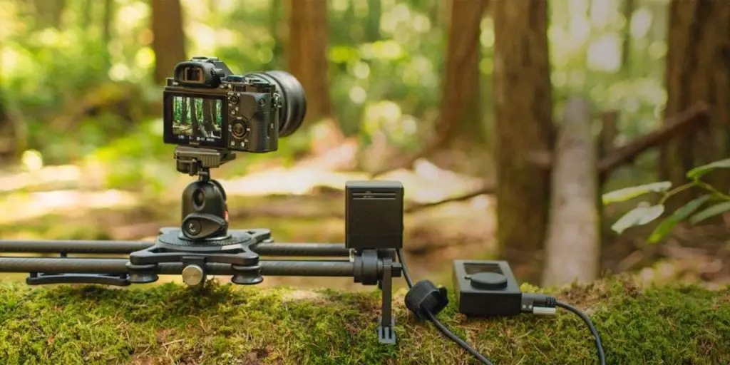 a black camera with slider in a forest 