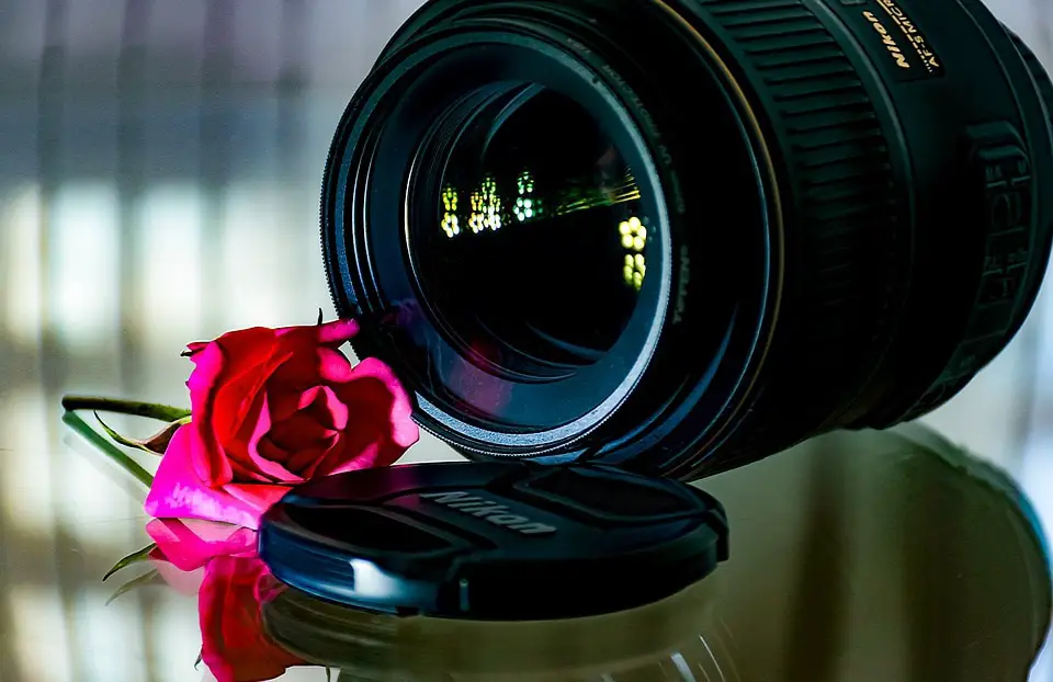 black lens with pink flower on a glass surface