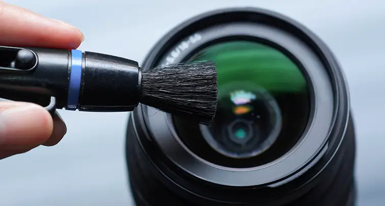 Cleaning the lens using a brush