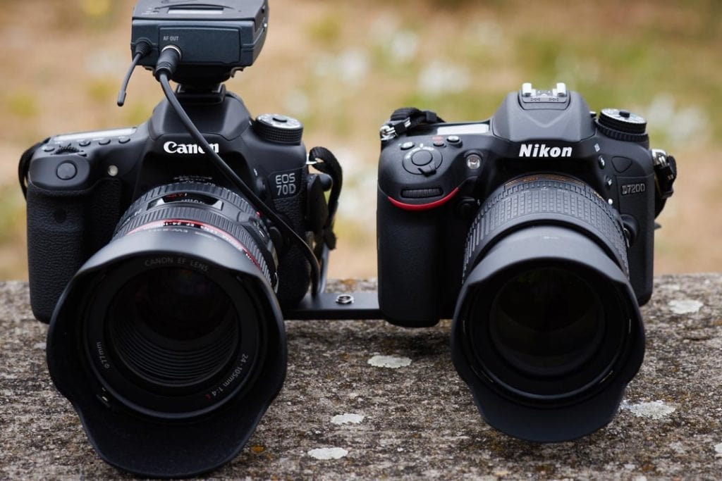 A canon camera beside a Nikon camera