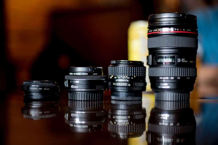 Four Canon lenses are lined up on the table