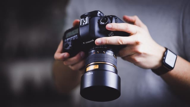 holding a superzoom camera