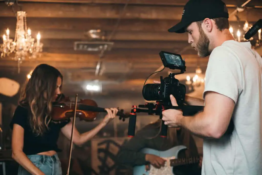 shooting scene with a girl playing violin and camera man