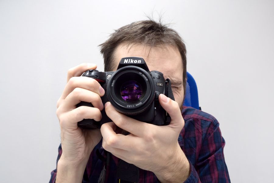 Man takes a photo with a Nikon D90