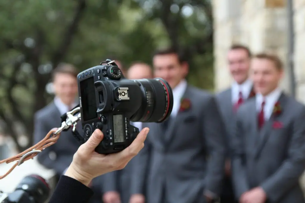 A person holding a black camera on a wedding