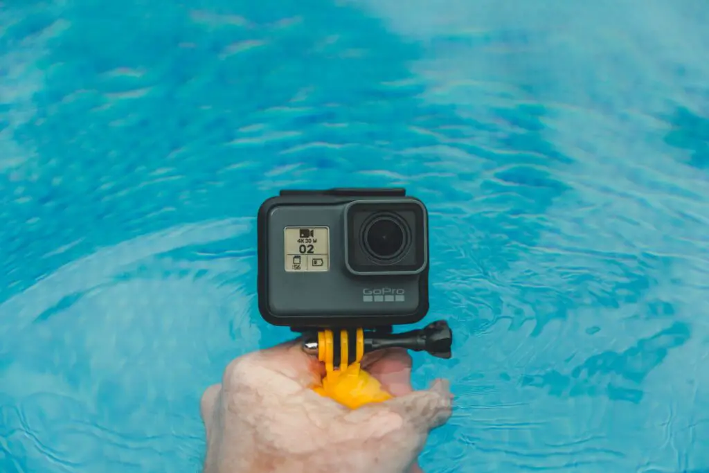 Person holding a GoPro camera in a water