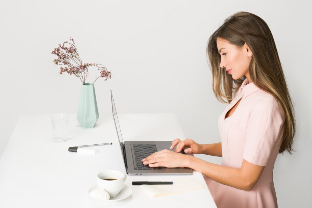 A woman in pink using her laptop